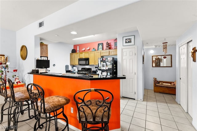 5855 Valley Dr Unit 1101, North Las Vegas, NV 89031 - kitchen with dark countertops, black appliances, light tile patterned floors, a peninsula, and visible vents