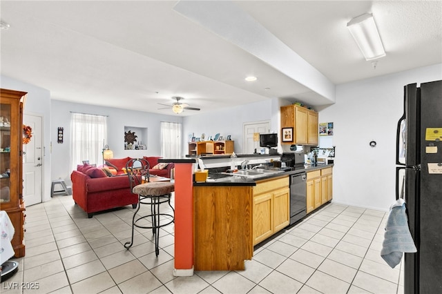 5855 Valley Dr Unit 1101, North Las Vegas, NV 89031 - kitchen featuring dark countertops, black appliances, open floor plan, a breakfast bar, and a peninsula