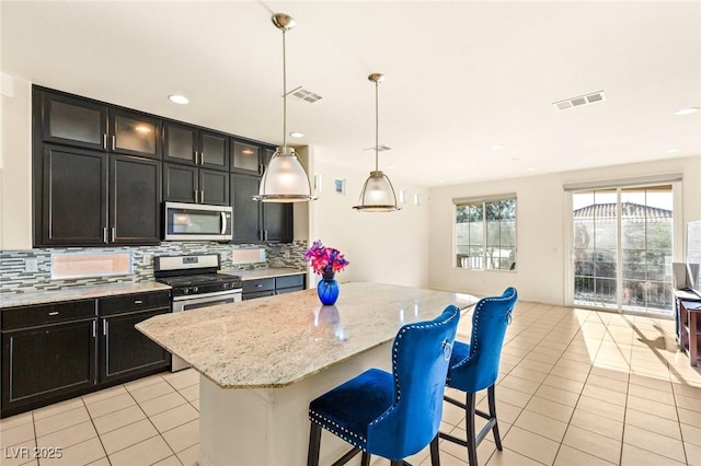 8276 Sorrel St, Las Vegas, NV 89139 - kitchen featuring appliances with stainless steel finishes, tasteful backsplash, visible vents, and light tile patterned floors