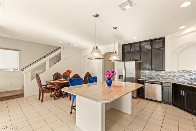 8276 Sorrel St, Las Vegas, NV 89139 - kitchen with a breakfast bar area, visible vents, appliances with stainless steel finishes, a kitchen island, and light tile patterned floors