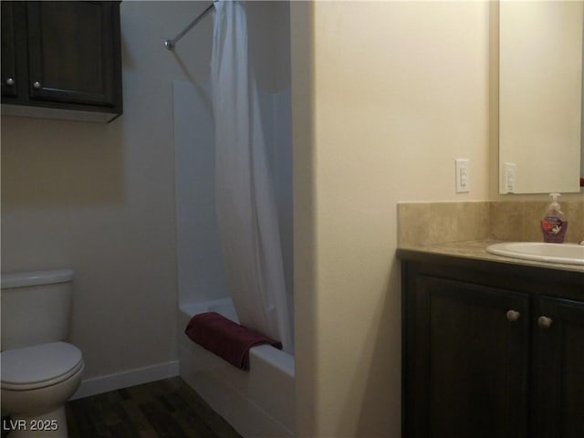 593 Ogden Ave, Ely, NV 89301 - bathroom featuring wood finished floors, toilet, vanity, shower / bath combo with shower curtain, and baseboards