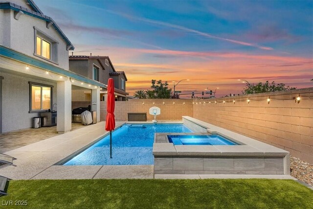 pool at dusk featuring a fenced in pool, a patio, a fenced backyard, and an in ground hot tub