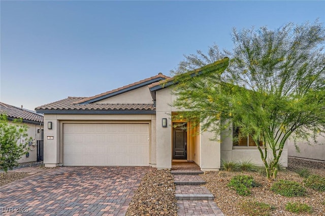 26 Sun Mirage Ave, Henderson, NV 89011 - view of front of property featuring a garage, a tile roof, stucco siding, and decorative driveway