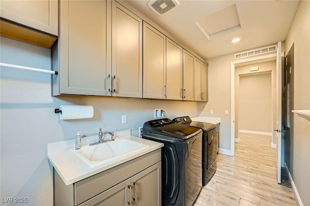 26 Sun Mirage Ave, Henderson, NV 89011 - laundry room featuring washing machine and clothes dryer, a sink, light wood-style floors, cabinet space, and visible vents