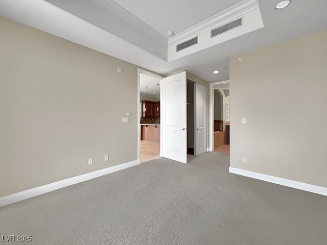 spare room with arched walkways, visible vents, crown molding, and baseboards