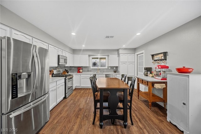 kitchen featuring light countertops, visible vents, a sink, decorative backsplash, and appliances with stainless steel finishes