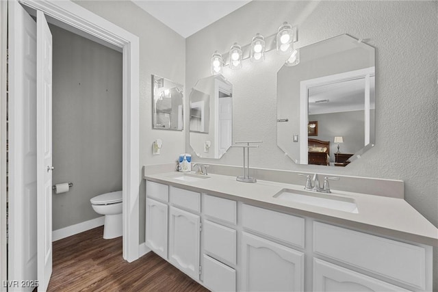 ensuite bathroom with ensuite bathroom, a sink, double vanity, and toilet