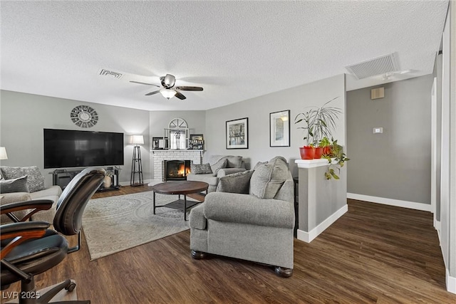 1619 Abby Ave, Henderson, NV 89014 - living area featuring a ceiling fan, a brick fireplace, dark wood-type flooring, and a textured ceiling