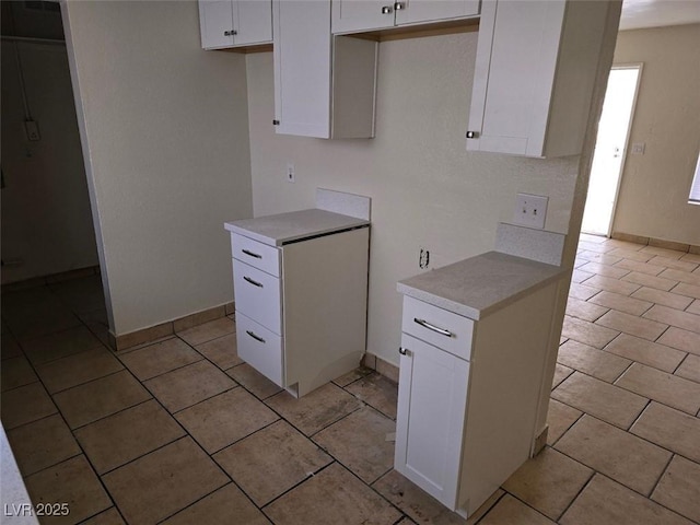 2740 Vita Dr, North Las Vegas, NV 89030 - kitchen with white cabinets, baseboards, light tile patterned floors, and light countertops