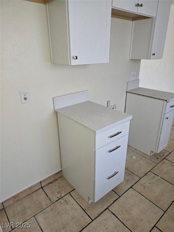 2740 Vita Dr, North Las Vegas, NV 89030 - kitchen featuring light countertops, light tile patterned flooring, and white cabinetry