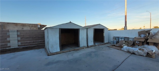2740 Vita Dr, North Las Vegas, NV 89030 - outdoor structure at dusk with a fenced backyard, an outbuilding, and a shed