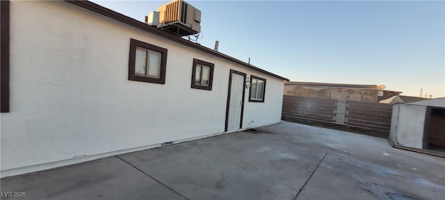 2740 Vita Dr, North Las Vegas, NV 89030 - property exterior at dusk with fence, a patio area, central AC unit, and stucco siding