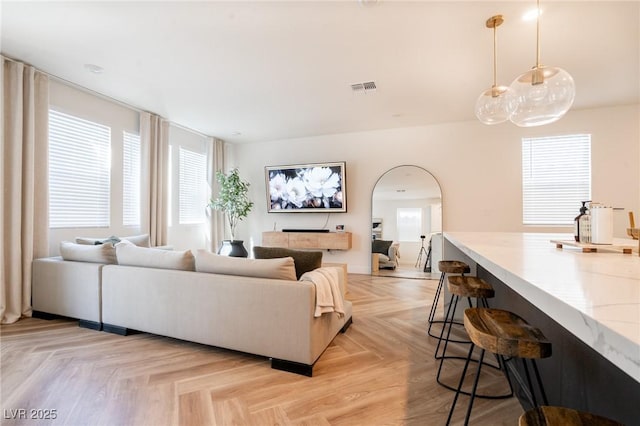 living room featuring visible vents and arched walkways