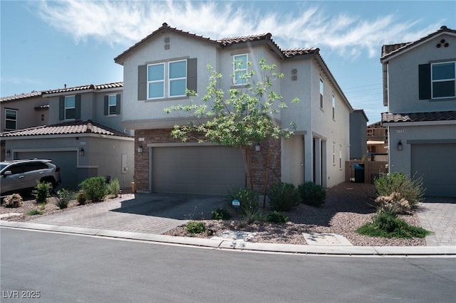view of front of property featuring stucco siding, an attached garage, decorative driveway, and a tiled roof