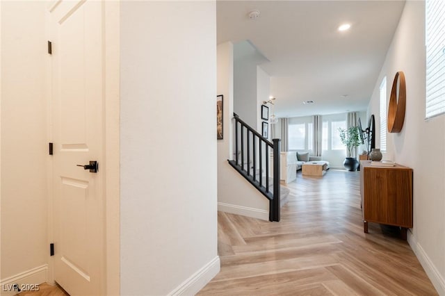 hallway featuring baseboards, stairs, and recessed lighting