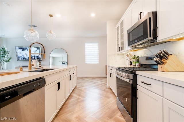 kitchen with stainless steel appliances, visible vents, glass insert cabinets, tasteful backsplash, and white cabinetry