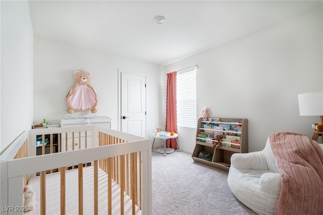 bedroom featuring a crib and carpet