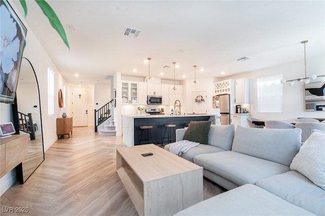 living room featuring stairs, visible vents, and recessed lighting