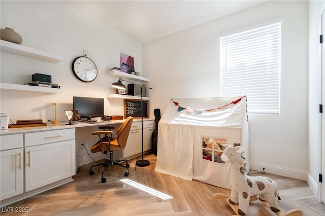 office featuring built in desk, light wood-style floors, and baseboards