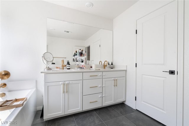 full bathroom with a tub to relax in, tile patterned flooring, double vanity, visible vents, and a sink
