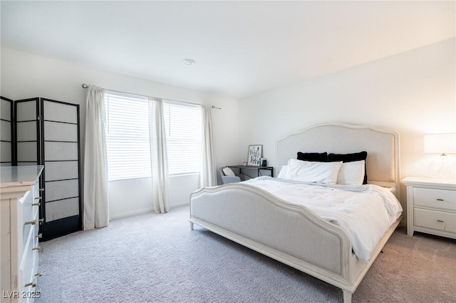 bedroom featuring light colored carpet and baseboards