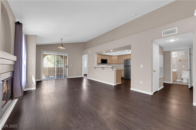 7950 W Flamingo Rd Unit 2019, Las Vegas, NV 89147 - unfurnished living room with dark wood finished floors, a glass covered fireplace, baseboards, visible vents, and lofted ceiling