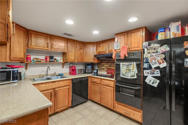 kitchen with a sink, black appliances, brown cabinets, light countertops, and visible vents