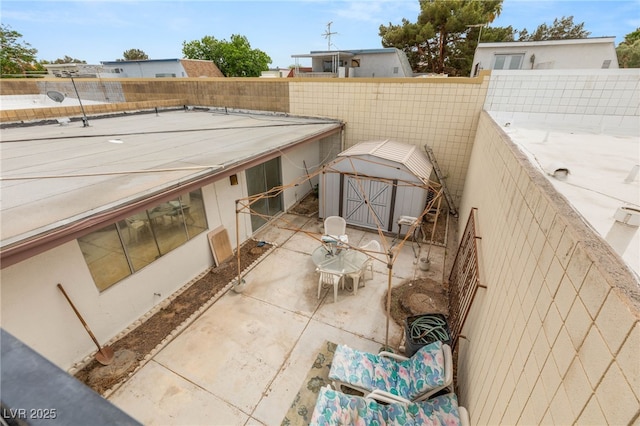 view of patio featuring fence, an outdoor structure, and a storage shed