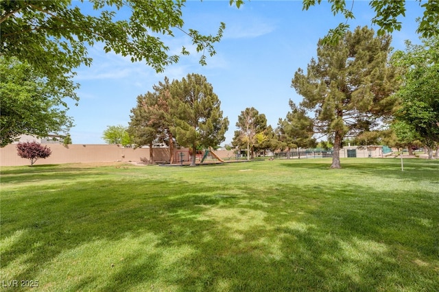 view of yard featuring fence and playground community