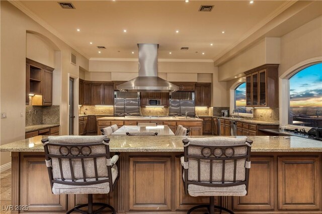 1520 Macdonald Ranch Dr, Henderson, NV 89012 - kitchen with island exhaust hood, a large island, visible vents, decorative backsplash, and appliances with stainless steel finishes