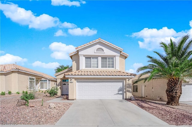 mediterranean / spanish home with a garage, stucco siding, a tile roof, and driveway