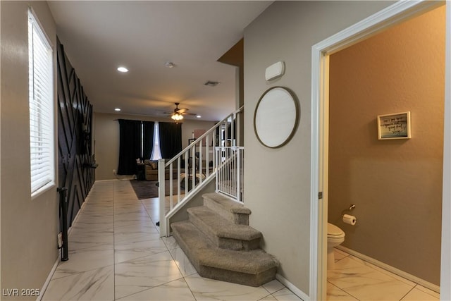 stairs featuring recessed lighting, marble finish floor, a healthy amount of sunlight, a ceiling fan, and baseboards