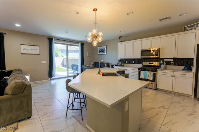 kitchen with stainless steel appliances, a sink, open floor plan, visible vents, and marble finish floor