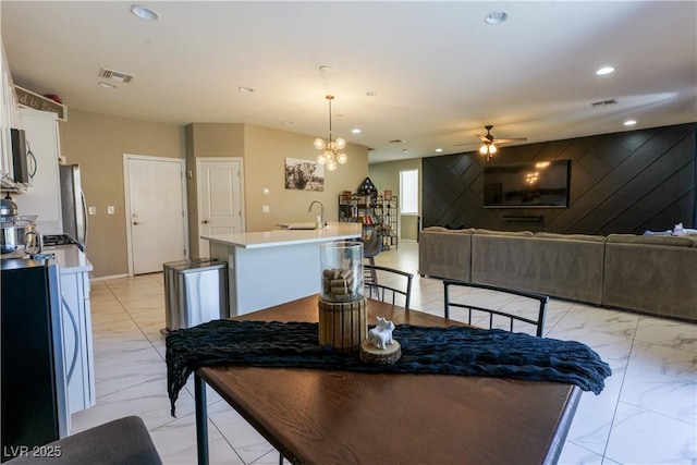 dining room with recessed lighting, visible vents, marble finish floor, and ceiling fan with notable chandelier