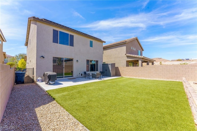 rear view of house featuring a yard, a patio, a fenced backyard, and stucco siding