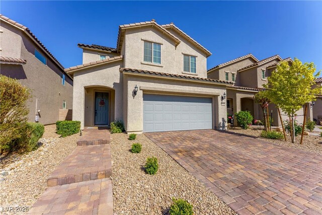 view of front of property featuring an attached garage, a tile roof, stucco siding, and driveway