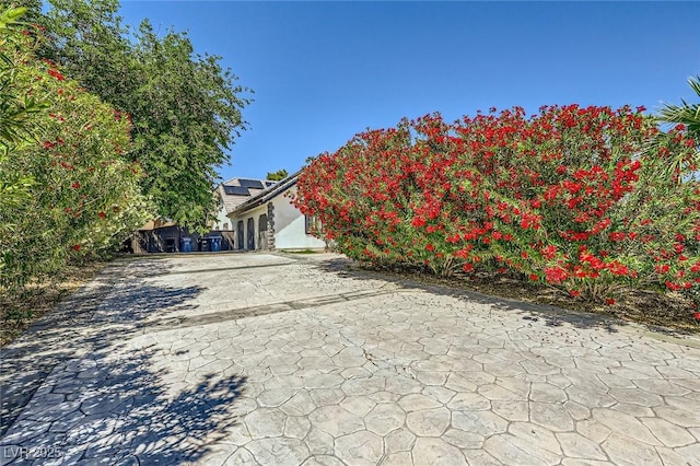 7165 Mira Monte Cir, Las Vegas, NV 89120 - exterior space with stucco siding, roof mounted solar panels, driveway, and a patio