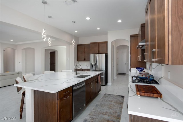 1130 Calico Rdg, Mesquite, NV 89034 - kitchen featuring appliances with stainless steel finishes, a kitchen breakfast bar, arched walkways, pendant lighting, and a large island