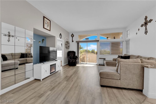living area featuring baseboards and light wood-style flooring