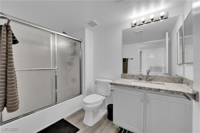 full bathroom with visible vents, wood finished floors, toilet, and vanity