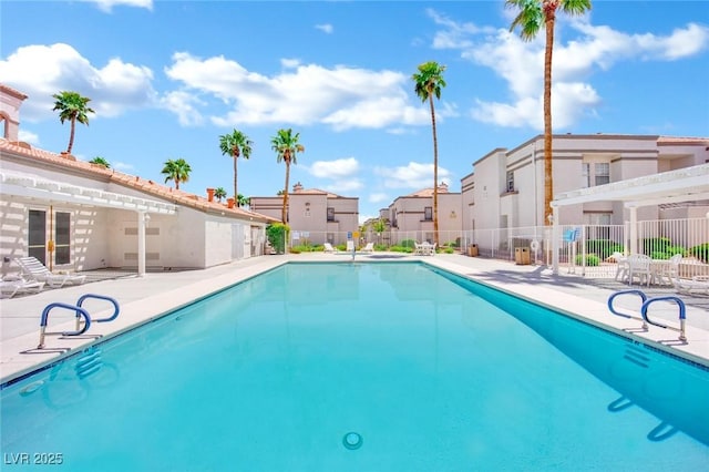pool with a residential view, a patio area, and fence