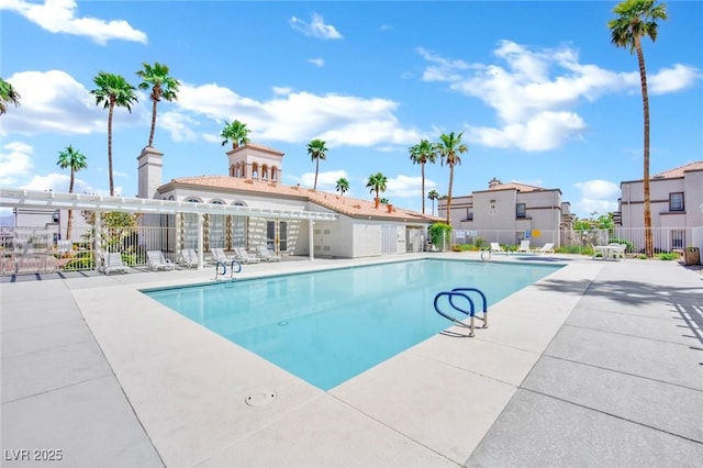 community pool with a patio and fence