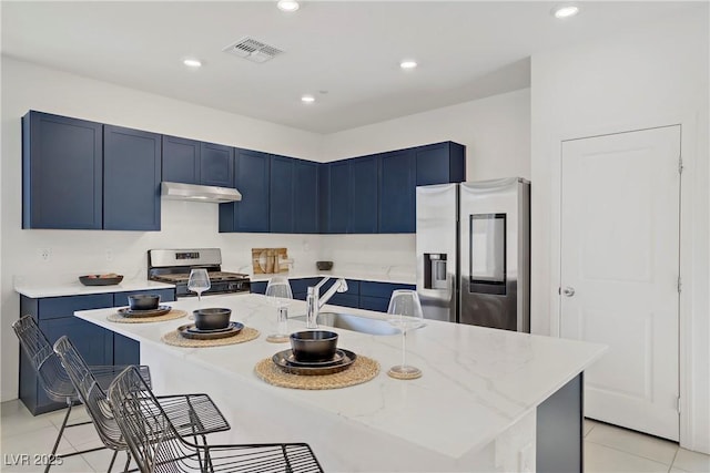 5692 Tinar St, Las Vegas, NV 89113 - kitchen with under cabinet range hood, blue cabinets, appliances with stainless steel finishes, and a sink