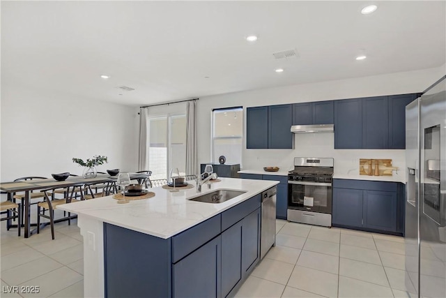 5692 Tinar St, Las Vegas, NV 89113 - kitchen with a sink, blue cabinets, light tile patterned floors, appliances with stainless steel finishes, and under cabinet range hood
