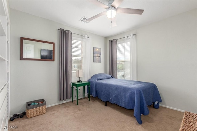 carpeted bedroom with baseboards, a ceiling fan, and visible vents