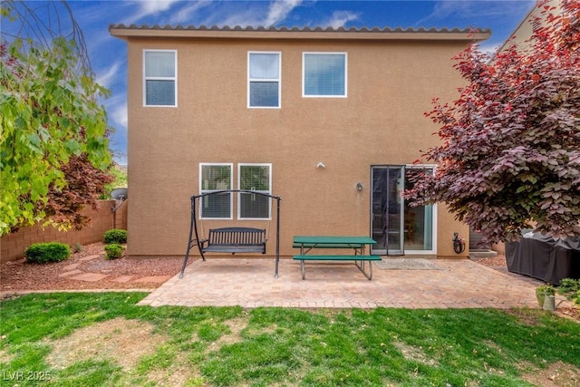 rear view of house with a patio, a fenced backyard, and stucco siding