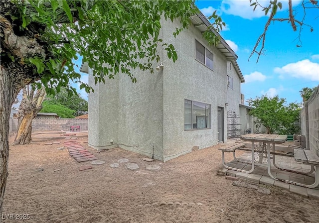 back of property with a patio area, a fenced backyard, and stucco siding