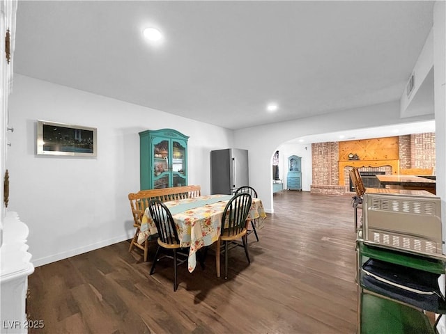 dining room featuring arched walkways, visible vents, baseboards, recessed lighting, and wood finished floors