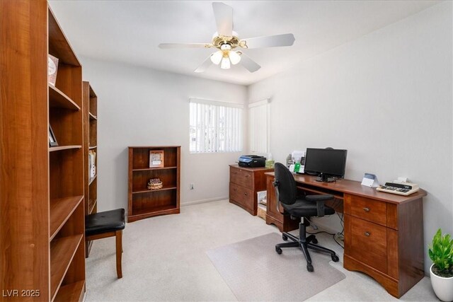office space featuring ceiling fan, light carpet, and baseboards