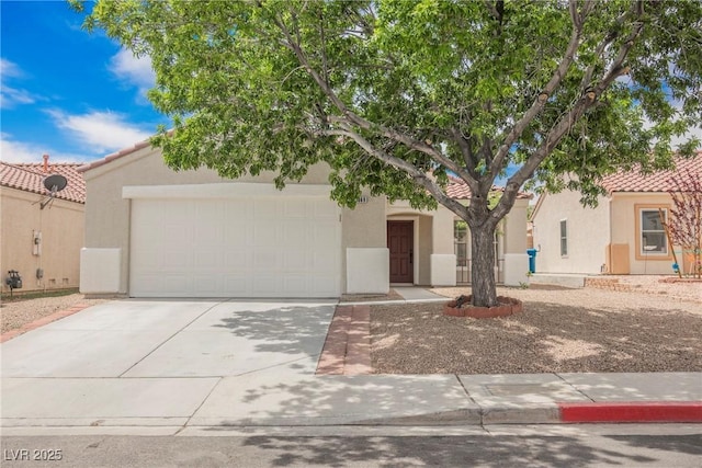 view of front facade with an attached garage, stucco siding, a tile roof, and concrete driveway